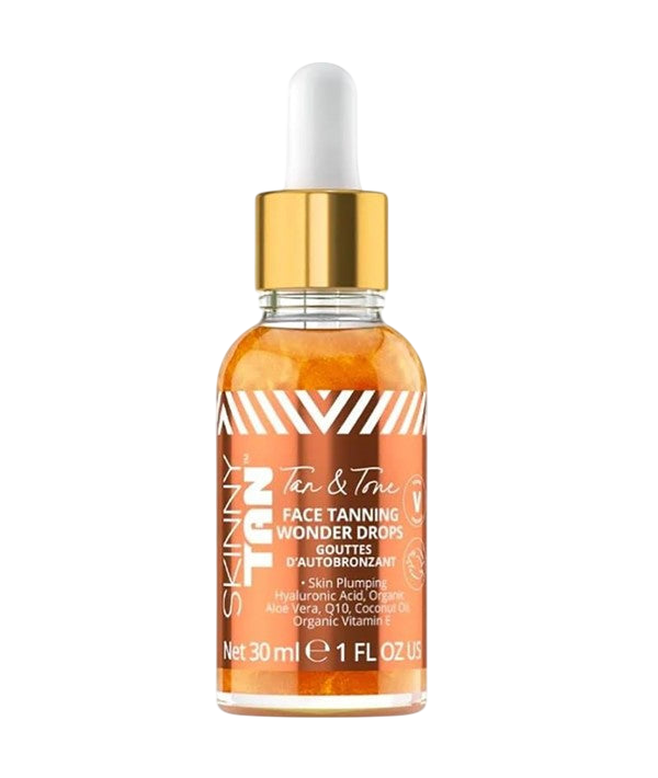 Clear glass dropper bottle with gold cap and white dropper, filled with bronze-tinted liquid, labeled Skinny Tan Tan & Tone Face Tanning Wonder Drops with a chevron-striped label listing Hyaluronic Acid, Organic Aloe Vera, Q10, Coconut Oil and Vitamin E, Net 30ml/1 FL OZ, on a plain light gray background.