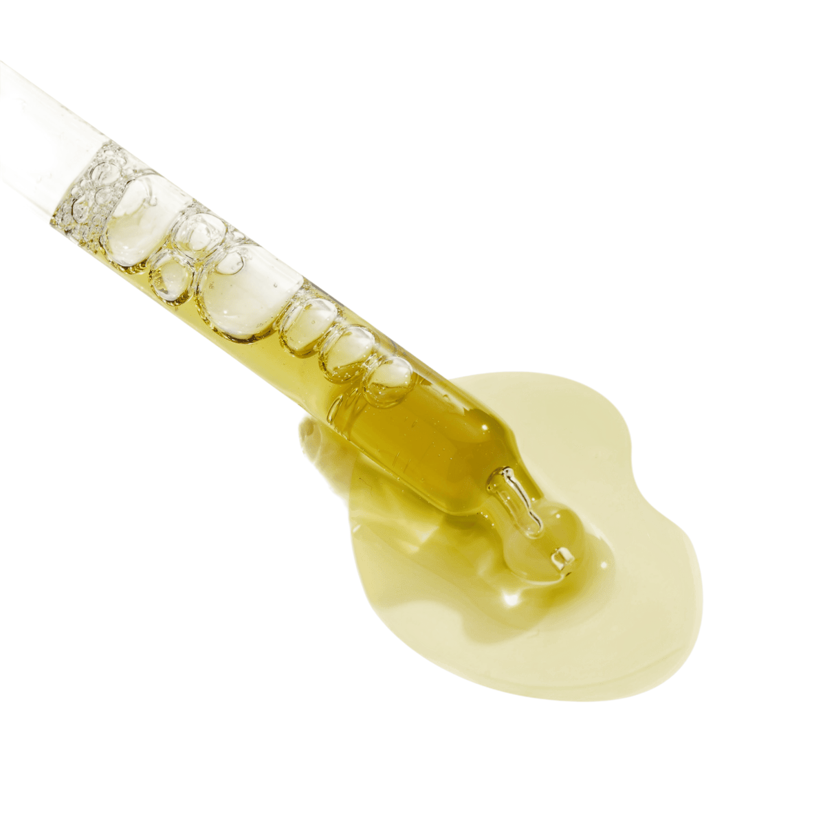 Close-up of a glass dropper releasing a pale golden serum that pools on a light grey background