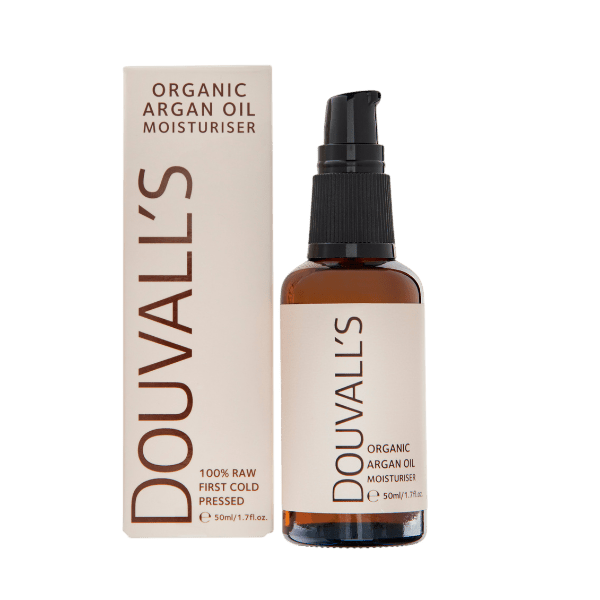 Douvalls cold-pressed argan oil moisturiser 50ml in an amber glass pump bottle beside its cream box on a light grey background